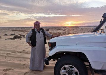 A bedouin guide by his car in the White Desert of Egypt